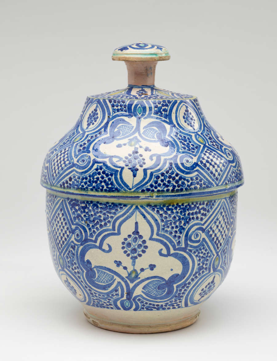A gray-white lidded bowl with delicate blue symmetrical decorations and a finial with turquoise decorations.