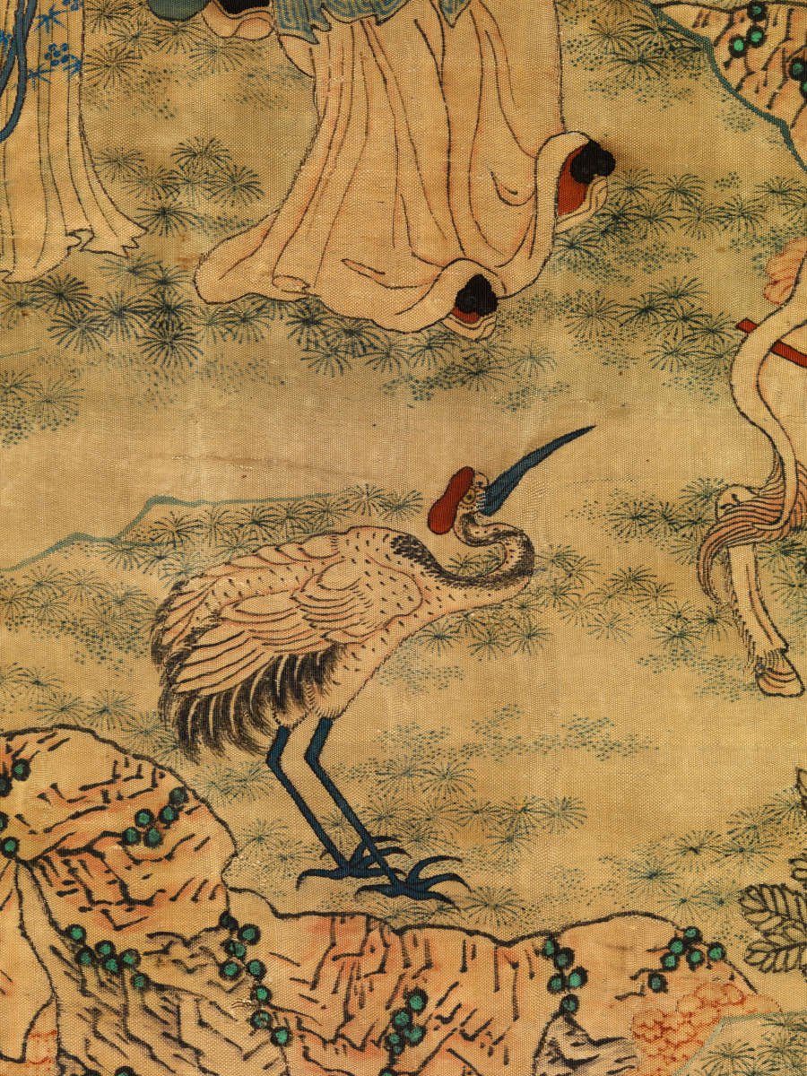 Detail showing a bird with a long slender neck, beak, and legs facing rightwards standing on the grassy edge of a cliff and in front of the robed legs of a figure.