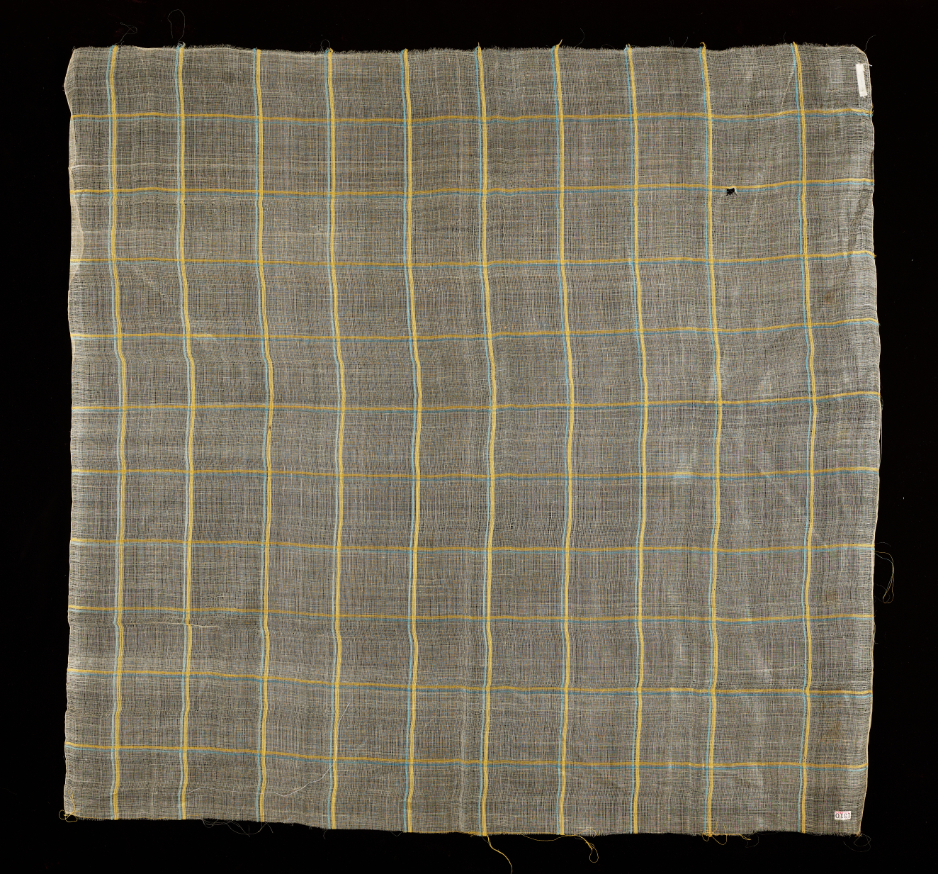 Square of transparent woven fabric on a dark background with a grid of yellow and green stripes whose colors slightly vibrate. The surface is soft and slightly wrinkled.