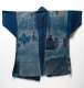 Back view of an indigo jacket with patchwork and visible fading.