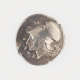 Round silver coin with irregular edges embossed with the profile of a man's head in a helmet, with Greek lettering surrounding it.
