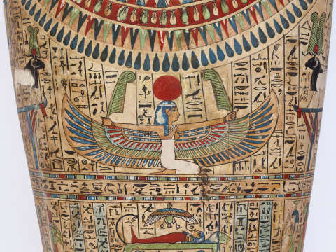 Painted coffin depicting a colorful winged human figure kneeling beneath a red sun with raised arms, bordered by hieroglyphs and decorative patterns.