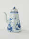 A white and blue teapot with floral decorations, a lid with a small semi spherical finial, spout, and a handle which is located approximately 90 degrees from the spout.