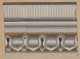 Horizontal decorative design featuring interlocking arched patterns in shades of gray with gold accents below rows of horizontal stripes, with repeating light vertical stripes above.