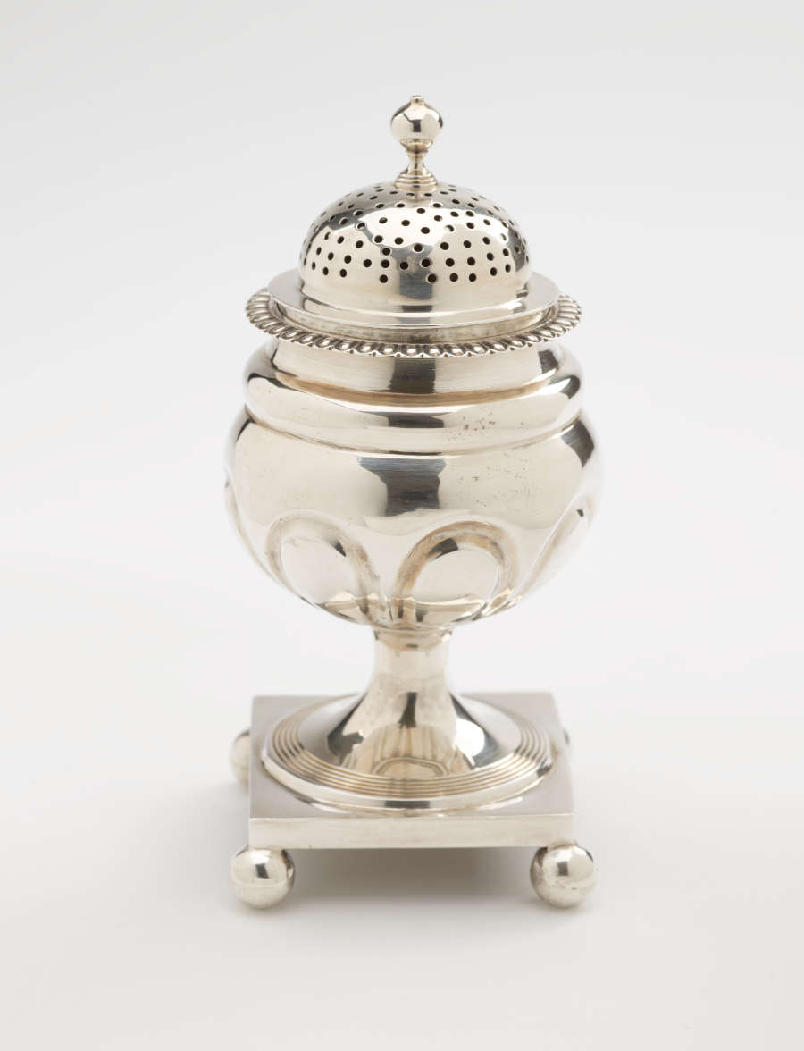  A silver caster with a square foot with small balls in each corner, the lid is perforated.
