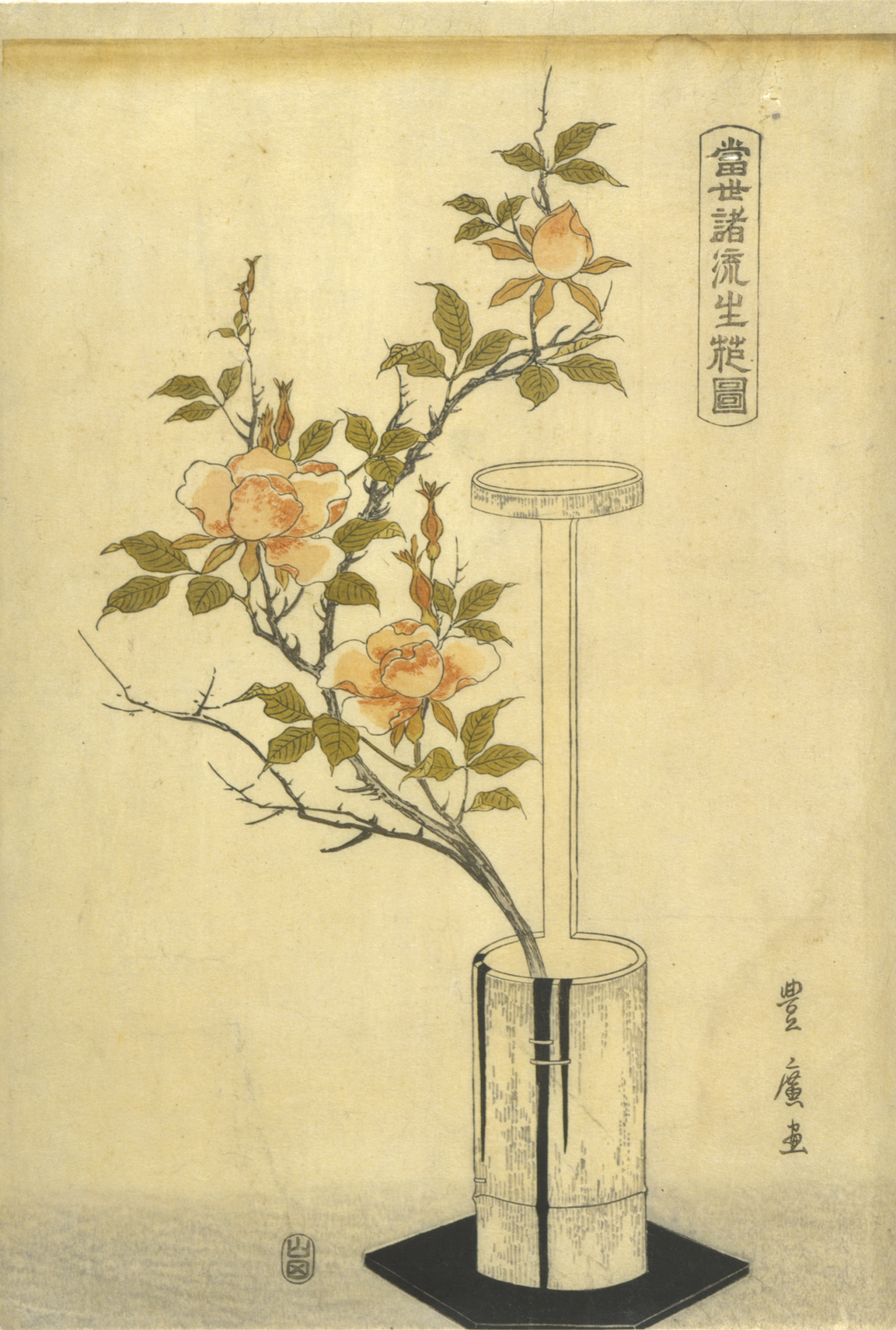 Peach-colored blossoms on a tall branch arranged in a tall, cylindrical metal vase set on a square of black cloth against a pale beige background.