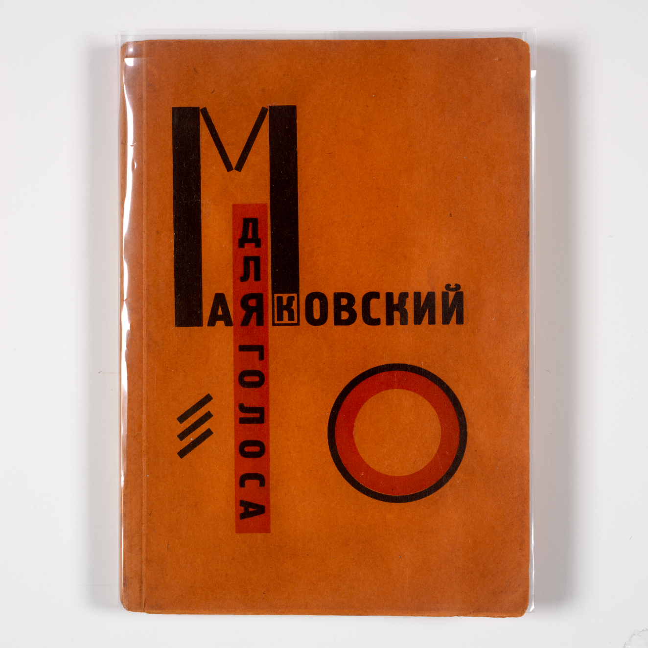 An orange book cover with bold black and red geometric text in Russian, arranged vertically and horizontally alongside a circle and three short diagonal lines. 