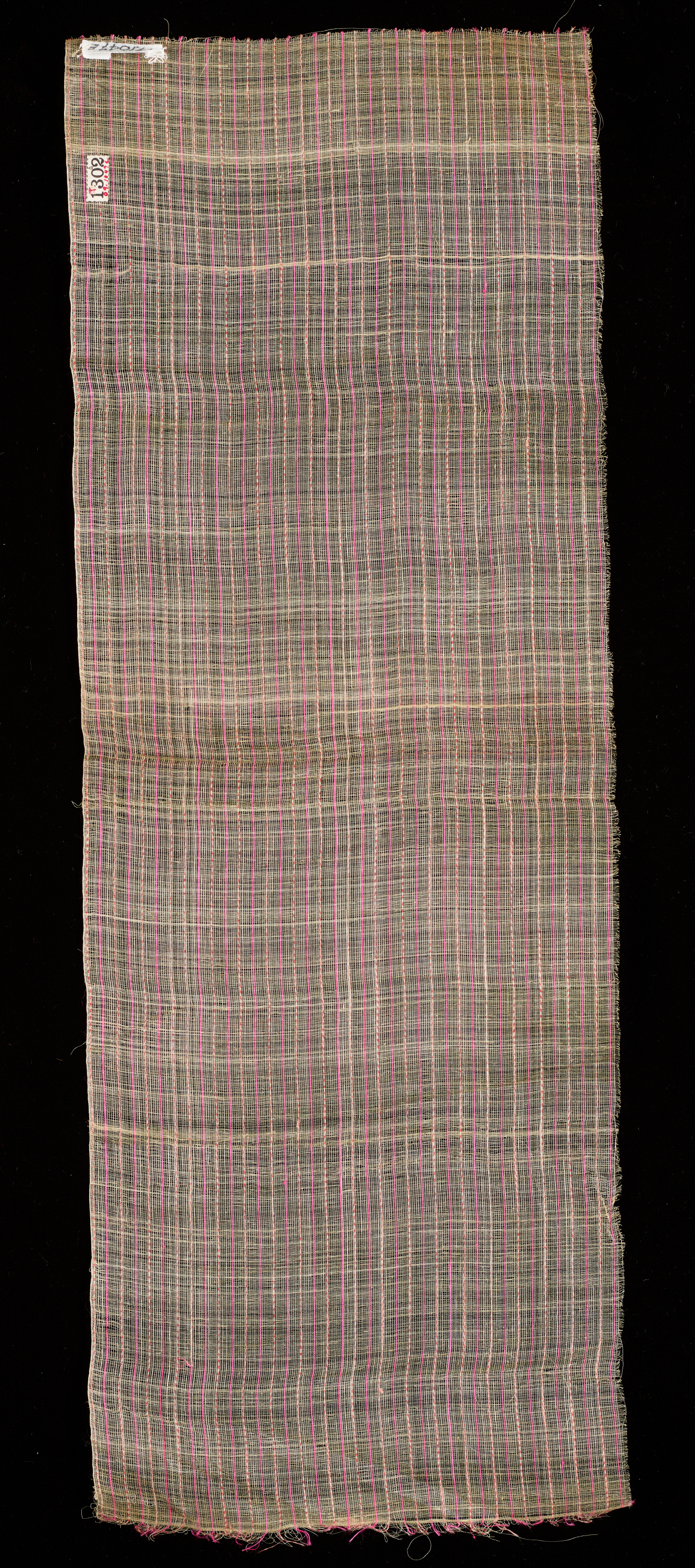 Long rectangle of transparent woven fabric on a black background. The rough surface is textured with a dense grid-like pattern made up of fine lines.