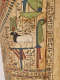 Painted detail on a coffin depicting a sacred ram with a black head below a red sun disk and a white body , standing on a platform, bordered by hieroglyphs.