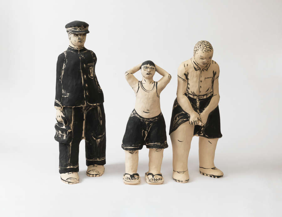 Three figures: one dressed in a uniform with a cap and satchel, a shorter figure in shorts and glasses with arms raised, and another in shorts bent forward.  