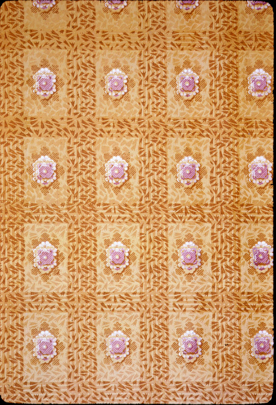 Repetitive design of white rosettes arranged in a grid set against a golden yellow background with a subtle leafy pattern.