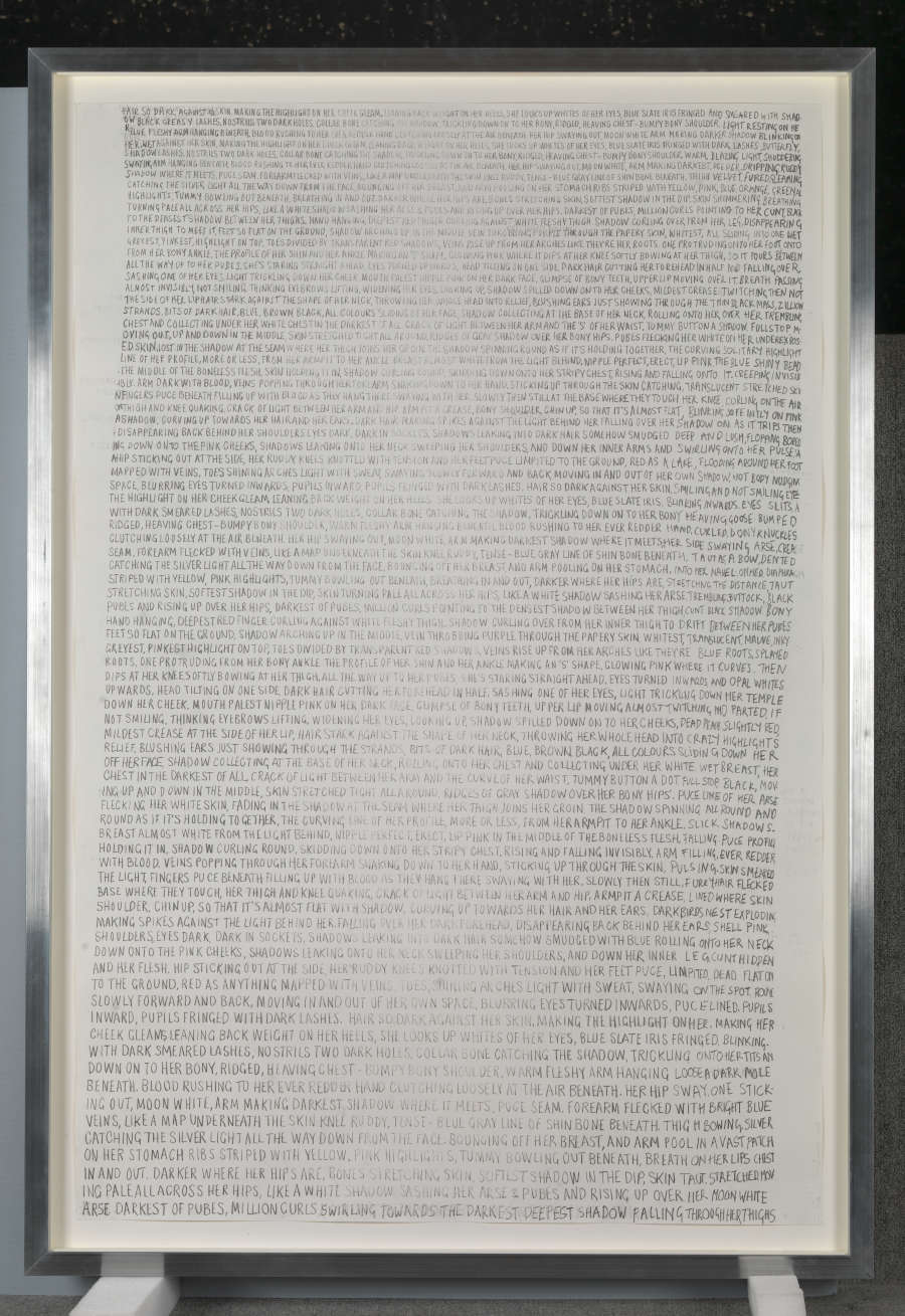 Framed artwork with dense black handwritten text, set in a black frame.