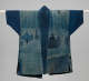Back view of an indigo jacket with patchwork and visible fading.