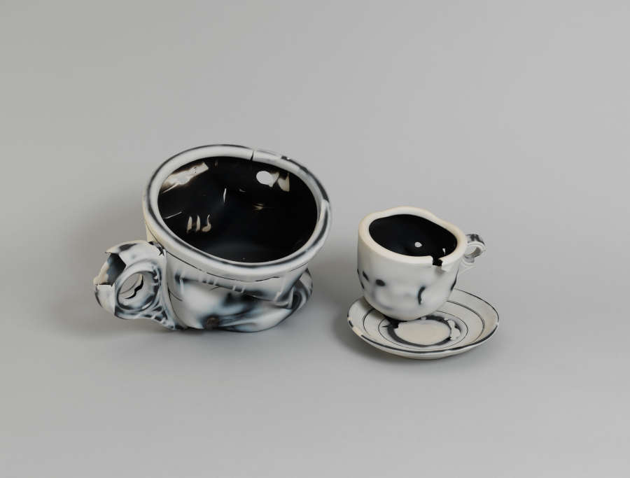 Black-and-white set of tea cups, the large one distorted and melting while the small one sits on a saucer. The painted outlines imitate the marks of an ink drawing.