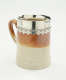 A brown and tan mug with a silver, scalloped rim.