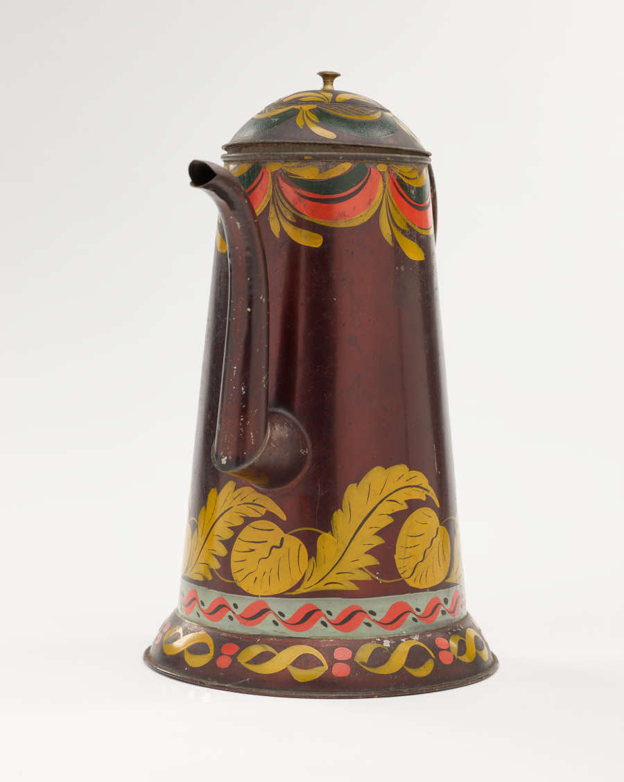 A shiny, brown colored coffee pot with yellow, white, and orange and abstract floral decoration. The spout has a right angle and then a curve.
