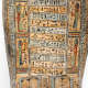 Close-up of a coffin panel, featuring hieroglyphic inscriptions surrounded by figures in red, blue, and green garments.