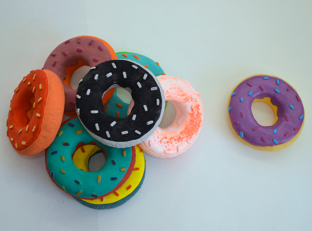 Marofske’s cast donuts, primarily plaster and gouache (L), and the original rubber donut dog toy (R).