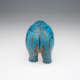 A back view of a blue sculpture of a standing hippopotamus with black outlines of birds, insects, plants and waves on its glossy surface. 