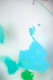 Close-up of bright turquoise paint on a smooth surface, forming soft, irregular shapes with subtle raised texture. A small detached dot hovers above, while surrounding colors fade into blur.