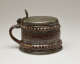 A brown and tan mug with a silver, scalloped rim.