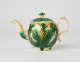 A bulbous teapot with white, green, and yellow floral decorations in the form of a leafy pineapple.