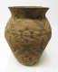 Round woven tan jar with a narrow base and bulging body with a flared neck. The jar features dark brown diagonally intersecting lines with 6-pointed stars in each square. 