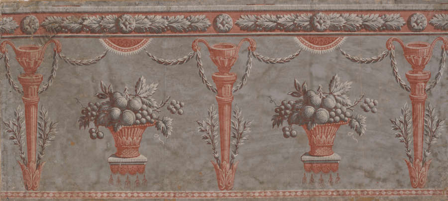 Classical motif of overflowing fruit-filled vases and pillars adorned with laurels in shades of terracotta and gray against a weathered gray background.