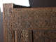 A close up of an intricately carved wooden corner with intricate geometric patterns with interwoven floral motifs and calligraphy. 