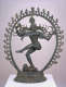 The Hindu god Shiva dancing within a flaming circle. His raised foot and flowing hair suggest movement, while multiple hands gesture and hold objects. He stands on a small figure.
