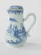 A white chocolate pot with blue decorations depicting floral and architectural elements.