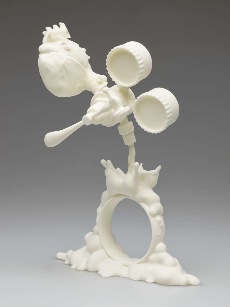 White plastic sculpture. At the top are suspended tools with an anatomical heart attached above left. A liquid-like form pours out from the tools and over a bracelet.