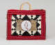 Rectangular leather and fur bag with red beaded border, black and white geometric inset border, and a central white circle featuring a red-outlined seal silhouette embedded in patterned fur piece. 
