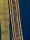 A close up of an ornate blue garment with a gold trimmed border featuring embroidered dragons.