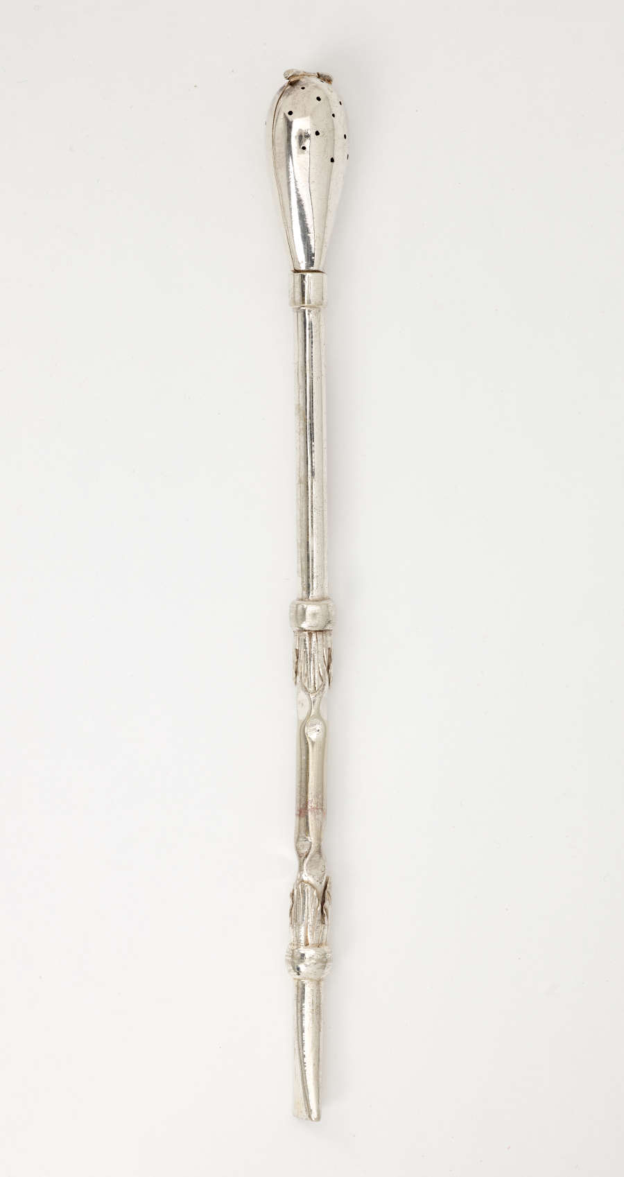 A silver utensil with a long skinny handle and bulbous end with small holes.