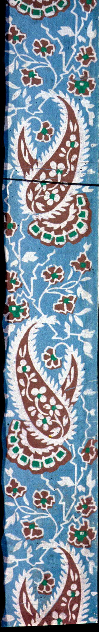 Thin strip with repeating orange teardrop and floral ornamentation with white and green accents, interspersed with white vine and leaf linework against a light blue background.