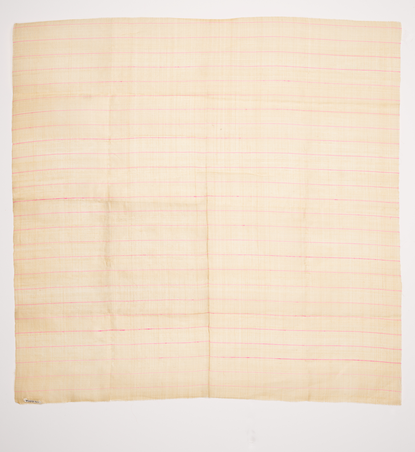Light beige square of fabric on a light background. Featuring delicate, crisp pink lines running horizontally along the smooth semi-transparent surface. Has creases like it’s been folded.