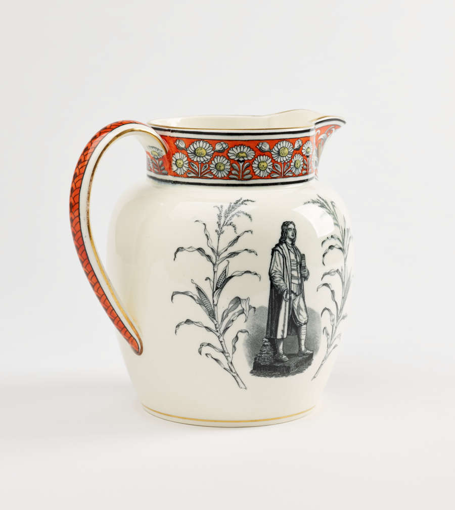 A jug with a band of red, yellow, and black daisy decorations at the top. A prominent gray tone figure and flora on the body of the vessel.
