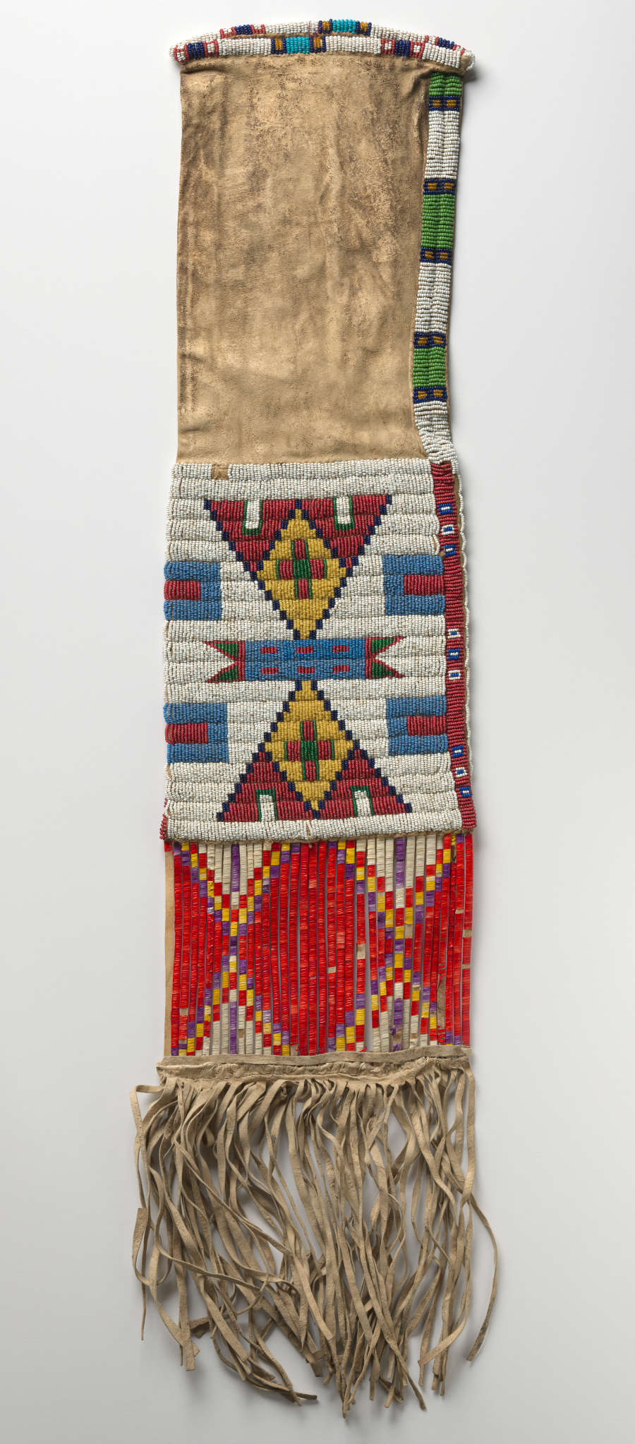 Back of a long velvety deerskin case, decorated with blocks of colorful geometric patterns in the lower half and similar borders along its upper sides. Tassels hang from the bottom edge.