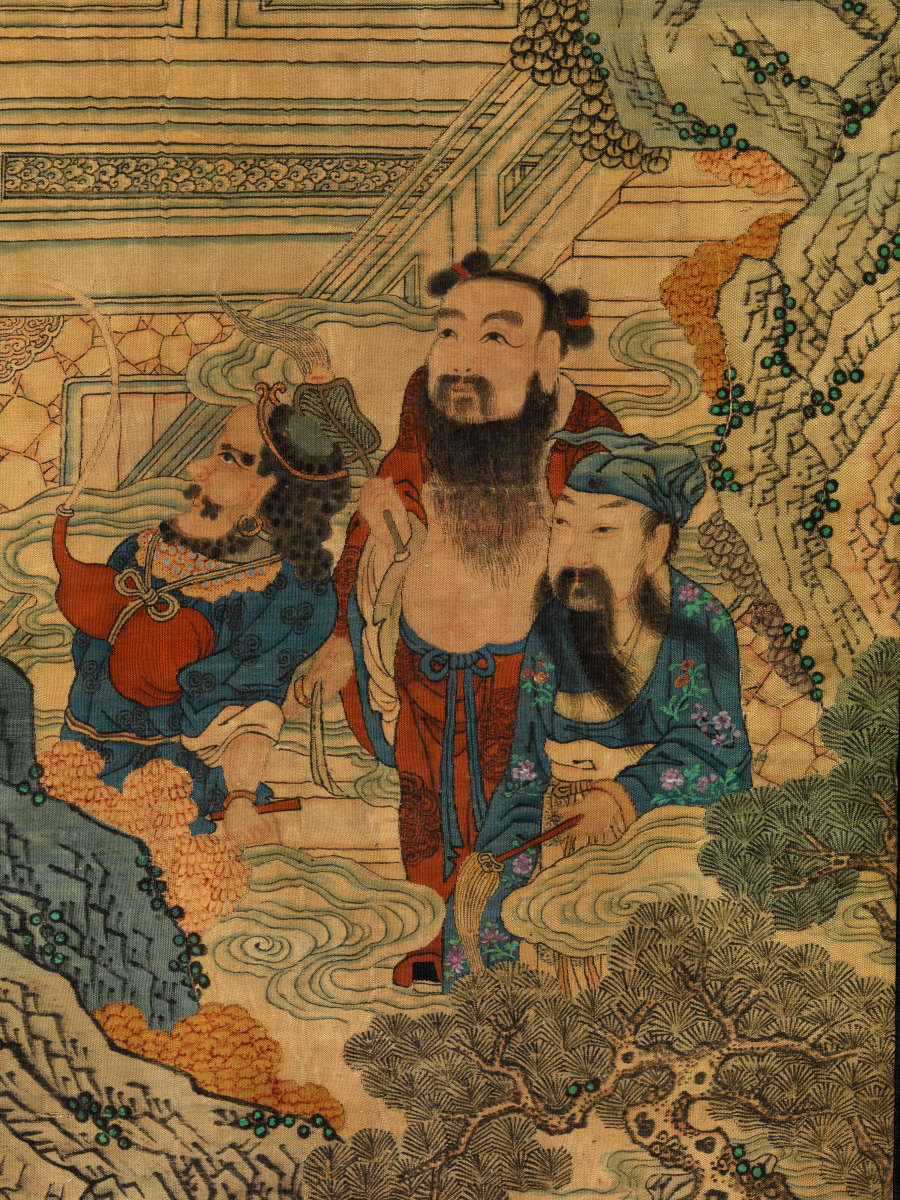 Detail of the scroll showing three figures dressed in blue and red, standing together at the bottom of the staircase, surrounded by clouds, trees and rocky terrain.