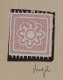 A pink square with a white floral design at center, accented by white dots and jagged edges set on a black background.