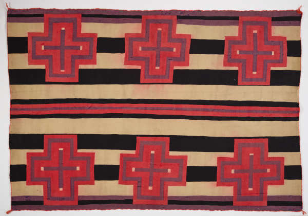 Black and cream striped woven blanket with six evenly spaced pink and purple bordered cross designs throughout. In the center there is a purple stripe in between two pink stripes. 