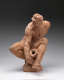 Realistic terracotta sculpture of a muscular bearded man sitting and leaning over in a dynamic pose, with his right arm stretched down to the base and his left arm behind supporting him.