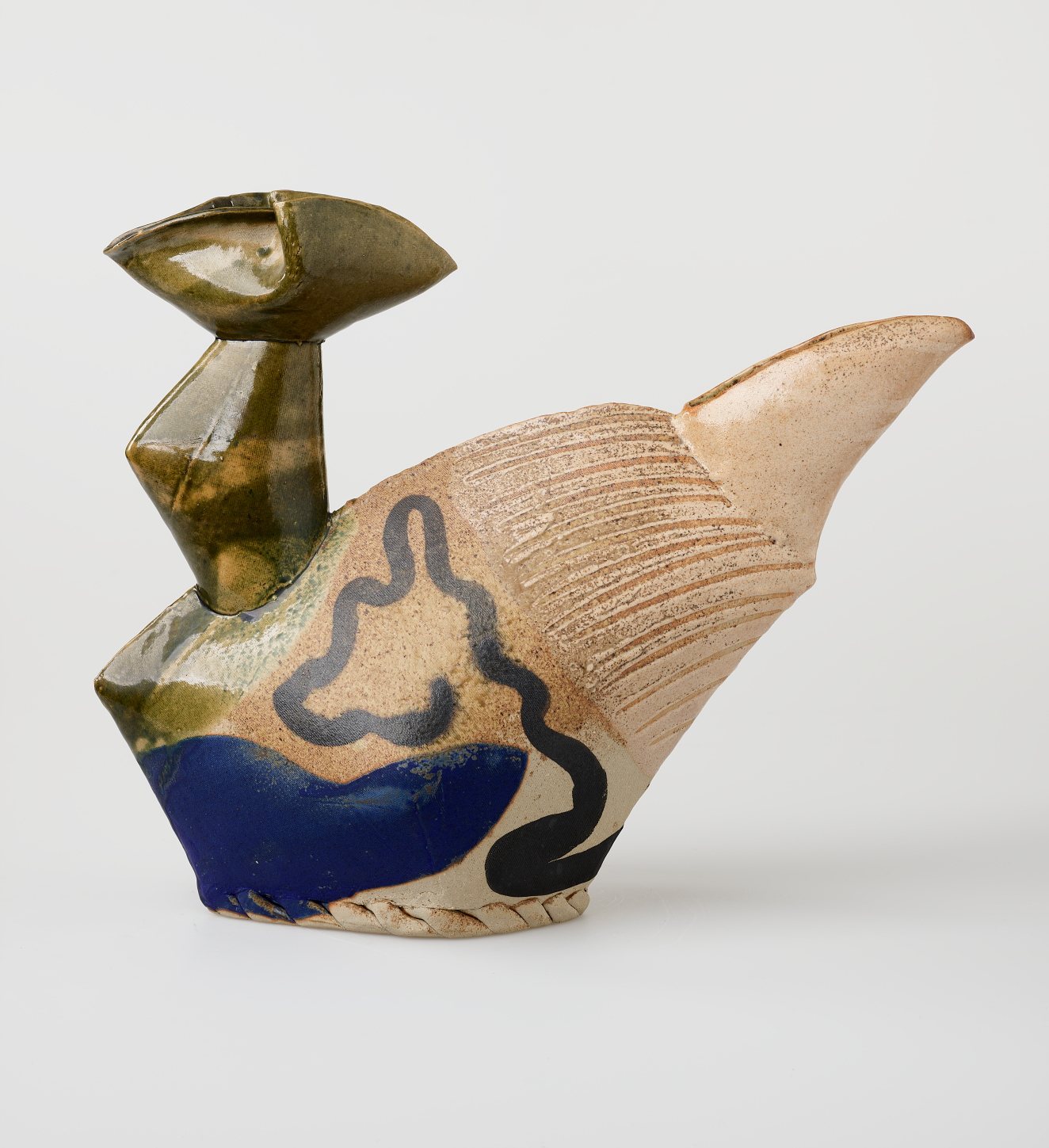 Sculptural vessel with a glossy green triangular neck and a matte beige body etched with fine raking lines. A blob shape and sweeping line in deep blue accent the surface.