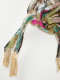 Raw cloth ends of a knotted textile coated in glittering teal, pink, gold, and silver. 