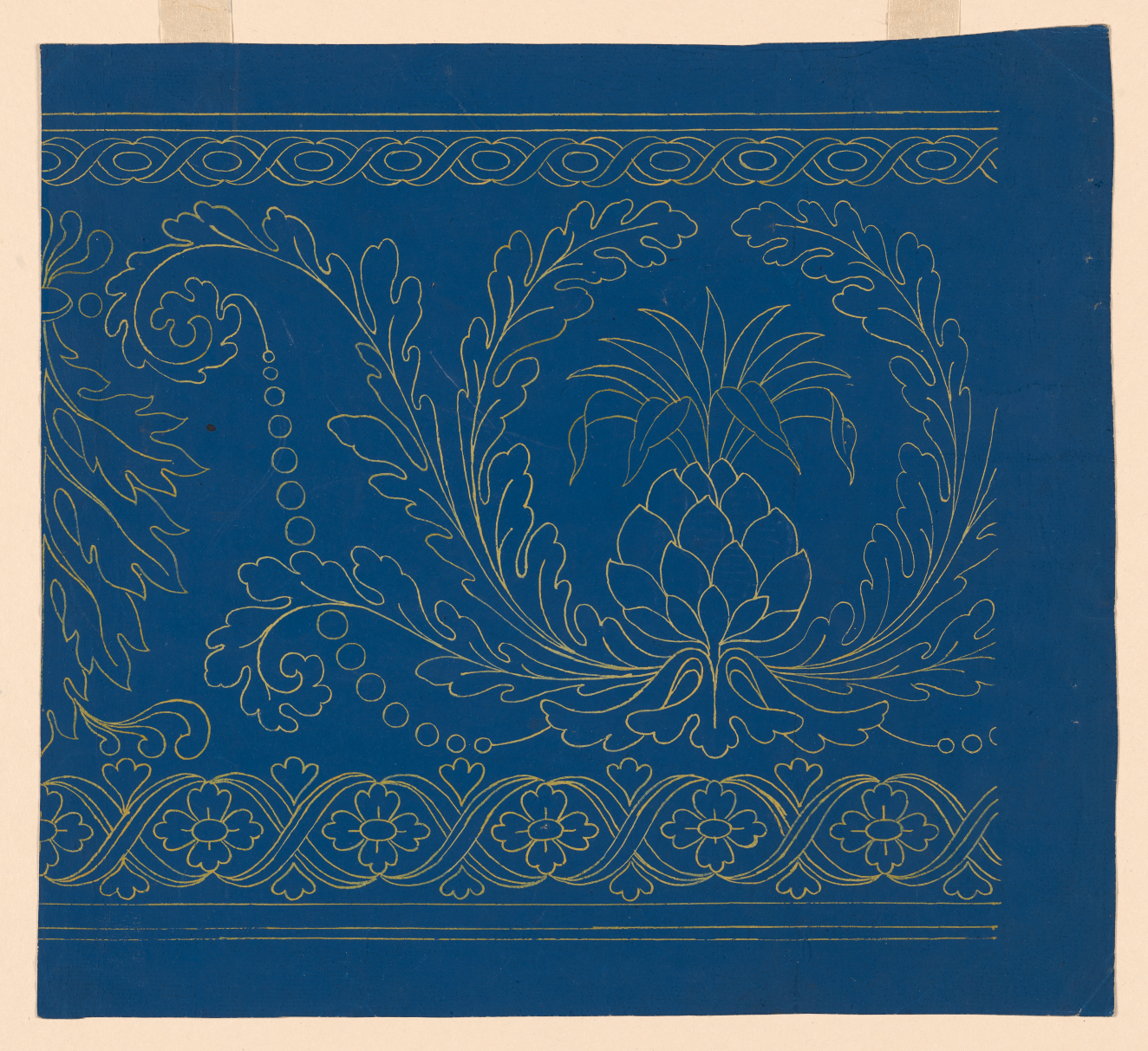 Wallpaper fragment of a gold pineapple motif with floral and leaf patterned linework set against a deep blue background.