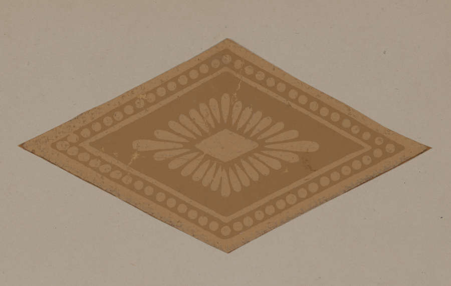 A brown diamond shaped emblem with petals radiating from the center surrounded by a decorative dotted border with solid bands.