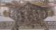 A silver oval relief panel depicting a central flowing-robed woman surrounded by playful cherubs and swirling drapery, enclosed in a gold-trimmed frame attached to a tray elevated by ornate legs. 