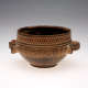A round, two-handled ceramic earthenware bowl with a dark interior, dark lower half, and upper band decorated with intricate tan and brown geometric patterns around the rim. 