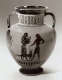 A black and white photo of a Greek ceramic vessel adorned with black figures and a dog, framed by intricate geometric ornament. 